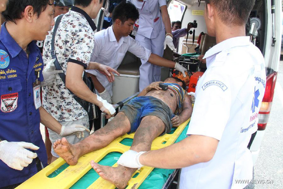 Rescuers help an injured person at the accident site in Phuket city, Thailand, on July 26, 2015. A total of 17 Chinese tourists were injured after their tour bus overturned in south Thailand's Phuket province on Sunday, China's consular office in Phuket said. [Photo/Xinhua]