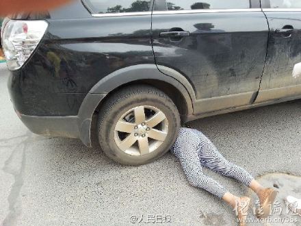 The old lady is seen underneath the car. [Photo from weibo] 