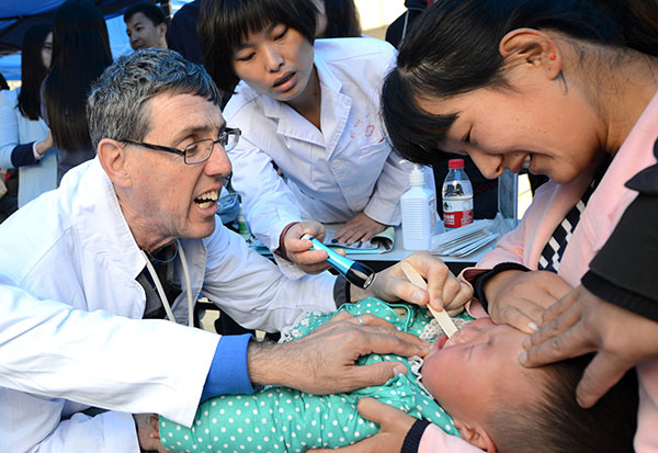 A child is treated by a US doctor in Zhengzhou, Henan province, in April as part of Operation Smile. Doctors working free have provided reconstructive surgery for 1,625 children with cleft lips and palates in China over the past 10 years.ZHANG TAO/CHINA DAILY 