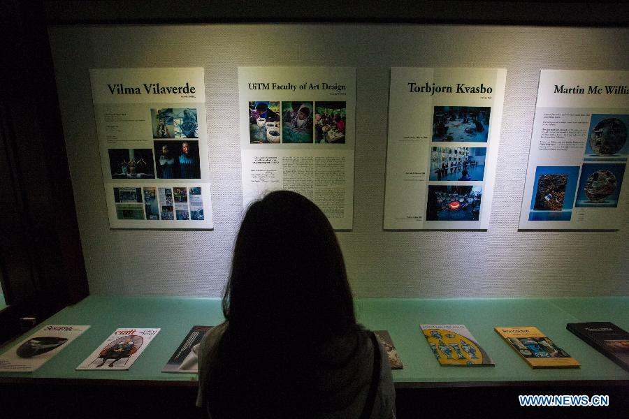 A visitor views documents exhibited at Beijing Guozhong Ceramic Art Center in Beijing, capital of China, July 29, 2015. 