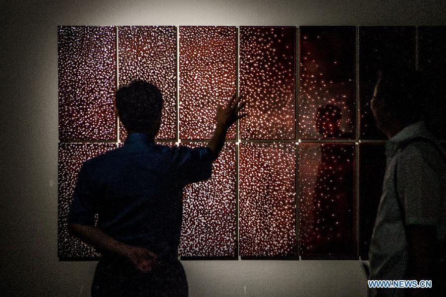 A visitor views a ceramic art work at Beijing Guozhong Ceramic Art Center in Beijing, capital of China, July 29, 2015. 