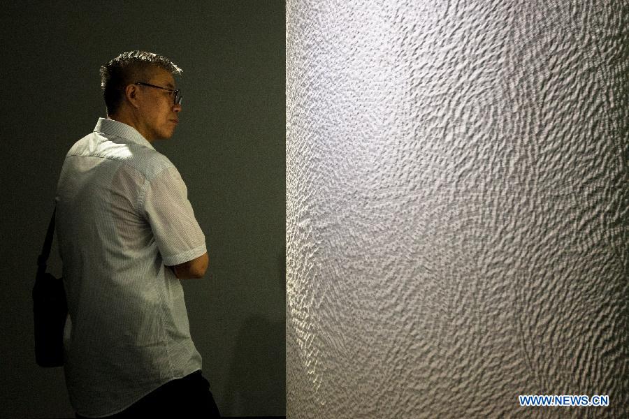 A visitor views a ceramic art work, Pillar by Jacques Kaufmann, at Beijing Guozhong Ceramic Art Center in Beijing, capital of China, July 29, 2015. 