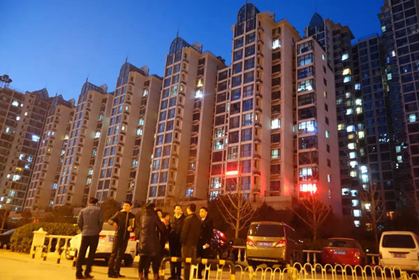 Real estate agents talk with potential clients at the entrance to a residential compound in Yanjiao, Hebei province, Jan 11, 2015. [Photo by Song Wei/chinadaily.com.cn]