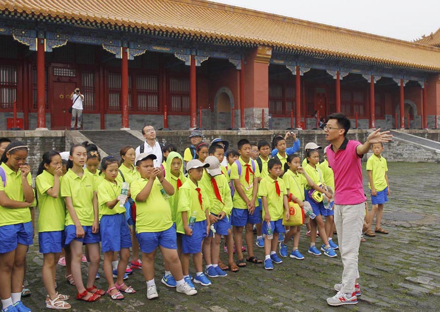 Students from Yunnan listen as a tour guide talks at the Palace Museum in Beijing on July 30, 2015. [Photo by Zhu Xingxin/chinadaily.com.cn]