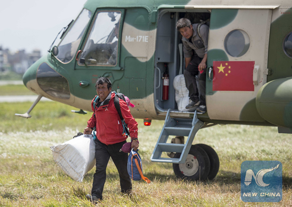 Rescuees step off a helicopter from an army aviation brigade of the Chengdu Military Region of the People's Liberation Army of China in Kathmandu, capital of Nepal, on May 13, 2015. [Photo/Xinhua]