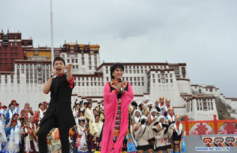 　Singers perform at the Potala Palace Square in Lhasa, southwest China's Tibet Autonomous Region, Aug. 3, 2015. Artists from Xinlianxin Art Troupe, organized by China's Central Television, started a tour in Tibet on Monday to mark the 50th anniversary of the establishment of Tibet Autonomous Region. [Photo: Xinhua]