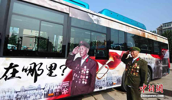 Yuan Yongfu gestures while posing with an advertisement on a bus in Jinan, East China's Shandong province, Aug 7, 2015. [Photo/Chinanews.com]