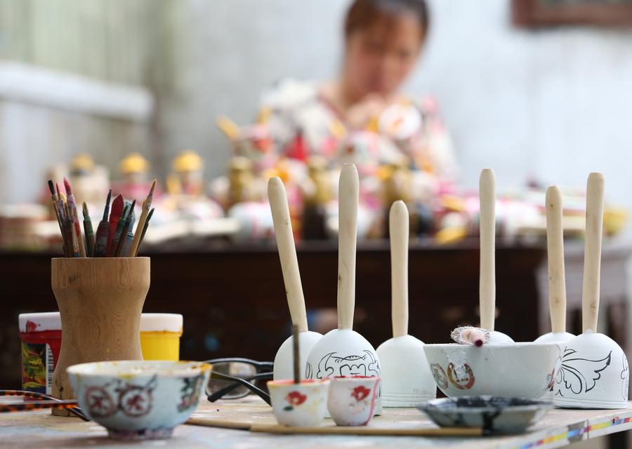  In Yang Lan's house, several partly-finished productions lay on the table, waiting for coloring. [Photo/Xinhua]