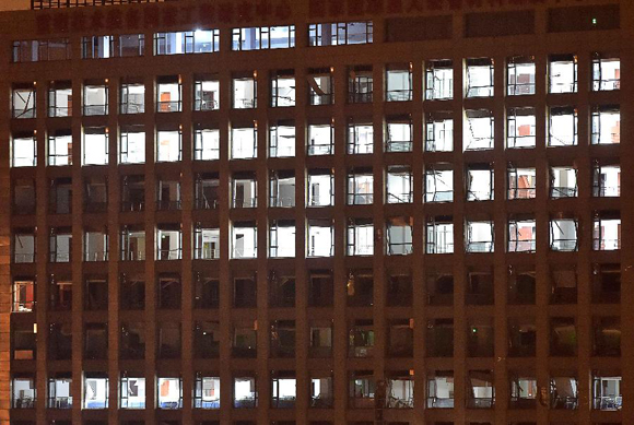 Shattered windows of a nearby building are seen after an explosion in the Binhai New Area in north China's Tianjin Municipality on Aug. 13, 2015. An explosion rocked the Binhai New Area in north China's Tianjin Municipality at around 11:30 p.m. Wednesday. The cause and casualties are not immediately known. [Photo/Xinhua]