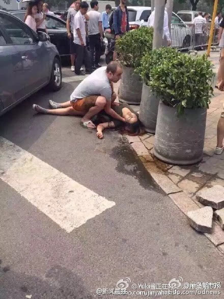 A woman is seen laying on the floor with blood in Beijing. [Photo: weibo.com]
