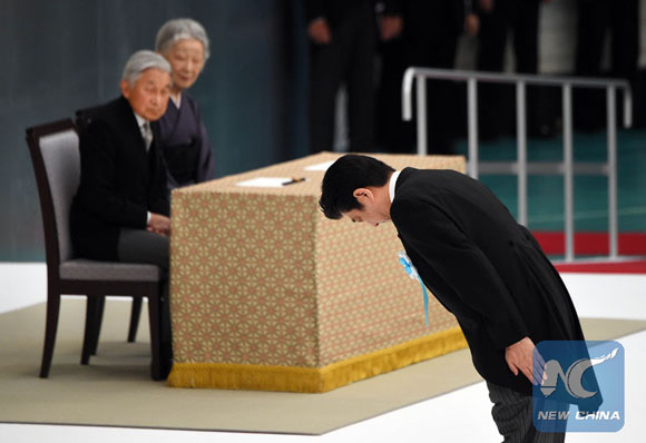 Japan's Prime Minister Shinzo Abe (R) bows before an altar as Emperor Akihito (back L) and Empress Michiko (2nd L) look on, as he prepares to read out his message of condolence during an annual memorial service for war victims in Tokyo on August 15, 2015. [Photo/Xinhua]