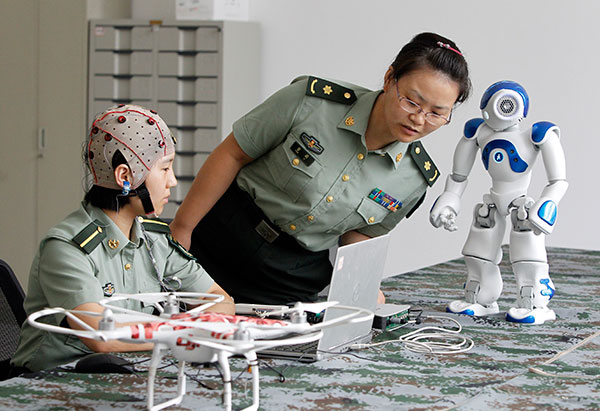 Two researchers at the PLA Information Engineering University test how to control robots with the &apos;mind&apos;.[Photo / China Daily]