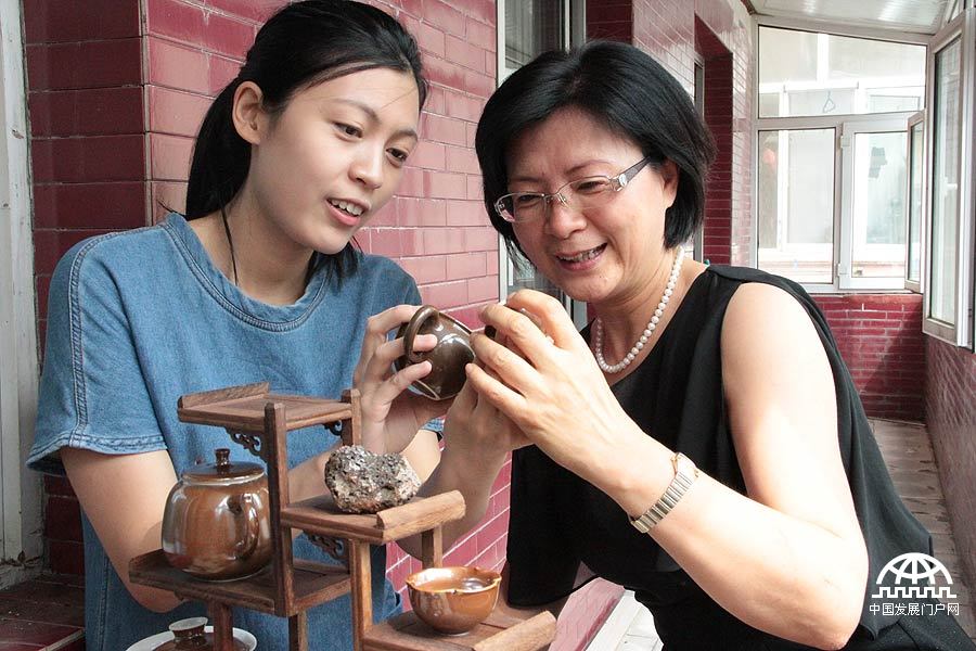 Niu Boran (L), 24, returned to her hometown in Harbin, the capital city of China’s northeastern Heilongjiang Province with her creative invention of a new kind of ceramics made from volcanic rocks. [Jiao Meng / Chinagate.cn]