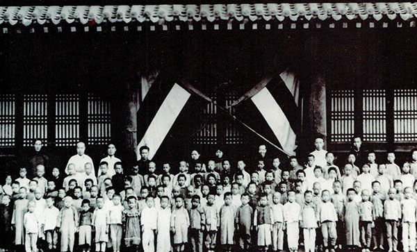 A 1921 photo of Yan Baohang (first from left, back row) with teachers and children at the charity school he founded in Liaoning province. Photo Provided to China Daily 