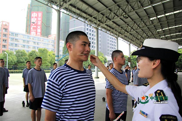 A member of the chorus trains his oral muscles with a chopstick in his mouth. [Photo/www.81.cn]