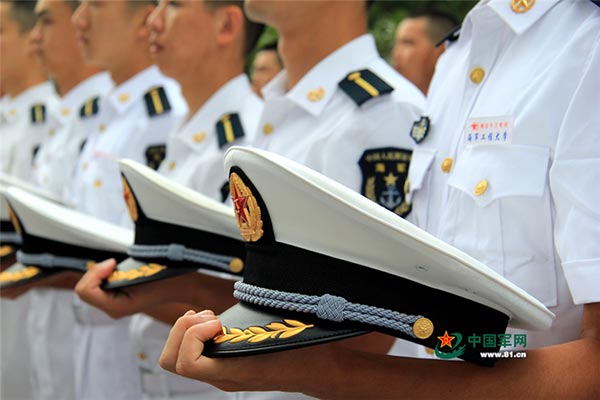 Soldiers hold their hats while standing in a line. [Photo/www.81.cn]