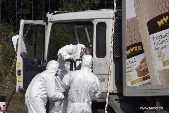 Investigators check the truck in which dozens of dead bodies were found at the side of the highway to Vienna near Parndorf, Austria, on Aug. 27, 2015. [Photo/Xinhua]