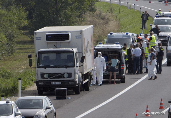 Investigators are seen around the truck in which dozens of dead bodies were found at the side of the highway to Vienna near Parndorf, Austria, on Aug. 27, 2015. A truck with Hungarian license plates parked at the side of the highway to Vienna early Thursday morning was discovered to have dozens of dead bodies inside, Austrian police said on Thursday. [Photo/Xinhua]