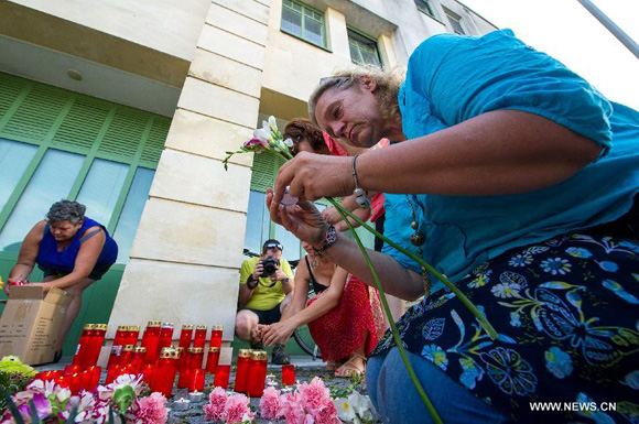 Local citizens light up candles to mourn the refugee victims in front of the police station in Eisenstadt, Austria, on Aug. 27, 2015. A truck with Hungarian license plates parked at the side of the highway to Vienna early Thursday morning was discovered to have dozens of dead bodies inside, Austrian police said on Thursday. [Photo/Xinhua]