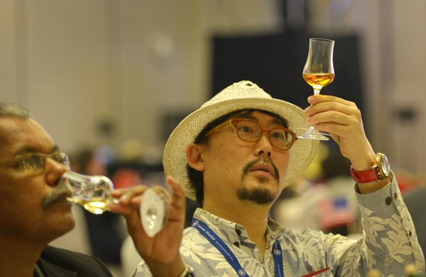 A judge checks a goblet of spirit at the Concours Mondial de Bruxelles Guiyang 2015 Spirits Selection in Guiyang, Guizhou province, on Wednesday.[Photo/China Daily]