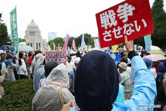Protesters hold placards during a rally against the controversial security bills in Tokyo, Japan, Aug. 30, 2015. [Photo/Xinhua]