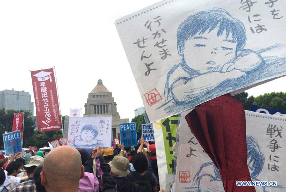 Protesters hold placards during a rally against the controversial security bills in Tokyo, Japan, Aug. 30, 2015. [Photo/Xinhua]