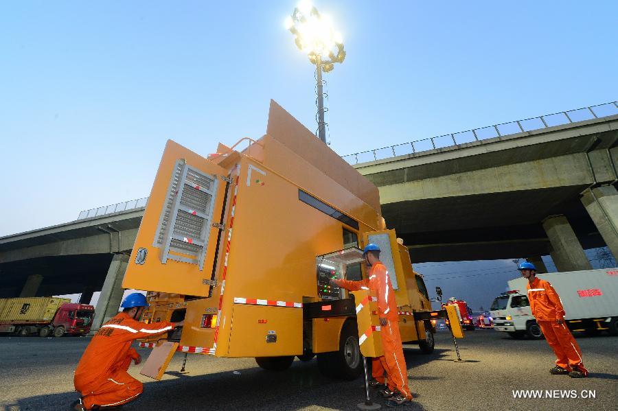 State Grid Tianjin Electric Co., Ltd., prepares trucks and equipment for emergency lighting to assist with the rescue operation in Binhai New District of north China's Tianjin Municipality, Aug. 13, 2015. [Photo / Xinhua]