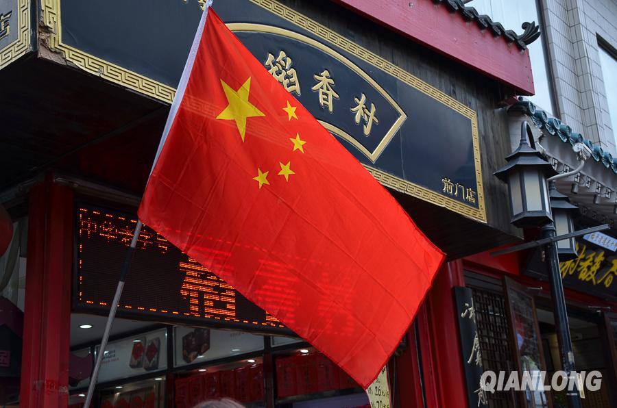 9月1日上午,大栅栏街道上的五星红旗挂在商户门前,迎风招展.