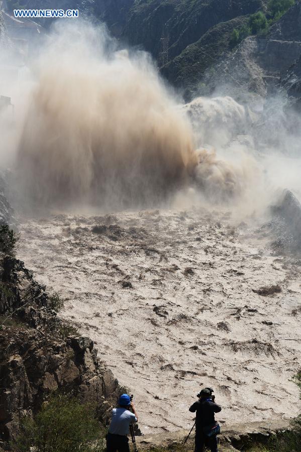 Water gushes out from the sluicing sediment hole of Taohekou in Liujiaxia Reservoir on the Yellow River, northwest China's Gansu Province, Sept. 6, 2015. The rock plug of the sluicing sediment hole of Taohekou is demolished successfully on Sunday. [Xinhua]