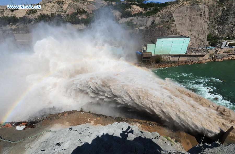 Water gushes out from the sluicing sediment hole of Taohekou in Liujiaxia Reservoir on the Yellow River, northwest China's Gansu Province, Sept. 6, 2015. The rock plug of the sluicing sediment hole of Taohekou is demolished successfully on Sunday. [Xinhua]