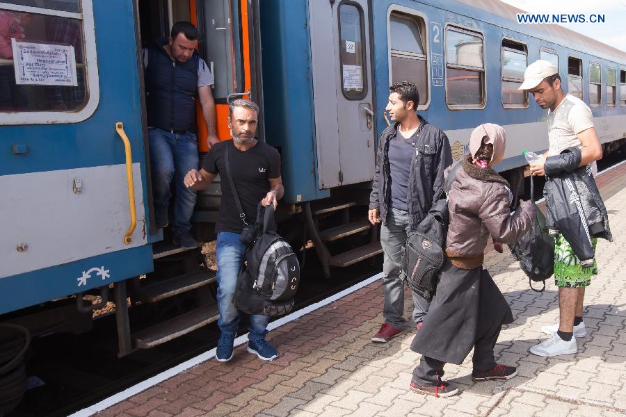 Illegal migrants traveling to Germany get off a train from Budapest at a railway station near Austrian border in Hegyeshalom, Hungary, on Sept. 6, 2015. Germany is bracing for an unprecedented influx of up to 800,000 asylum seekers this year as Europe deals with its biggest migrant crisis since the Second World War. [Xinhua]