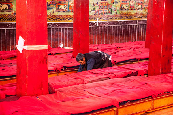 Tibetan Buddhist prays as he crawls from the monestery's entrance to the Buddha statue (not seen in this picture) and kowto, at Champa Ling Monastery. [Photo by Yuan Yong/Provided to chinadaily.com.cn] 