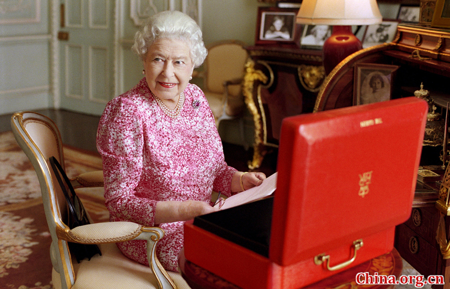 Britain&apos;s Queen Elizabeth sits in her private audience room in Buckingham Palace next to one of her official red boxes in which she receives documents and papers from government officials in the United Kingdom and the Commonwealth in this handout photograph released September 8, 2015 in London, to mark the moment she becomes Britain&apos;s longest reigning monarch. [Photo/China.org.cn]