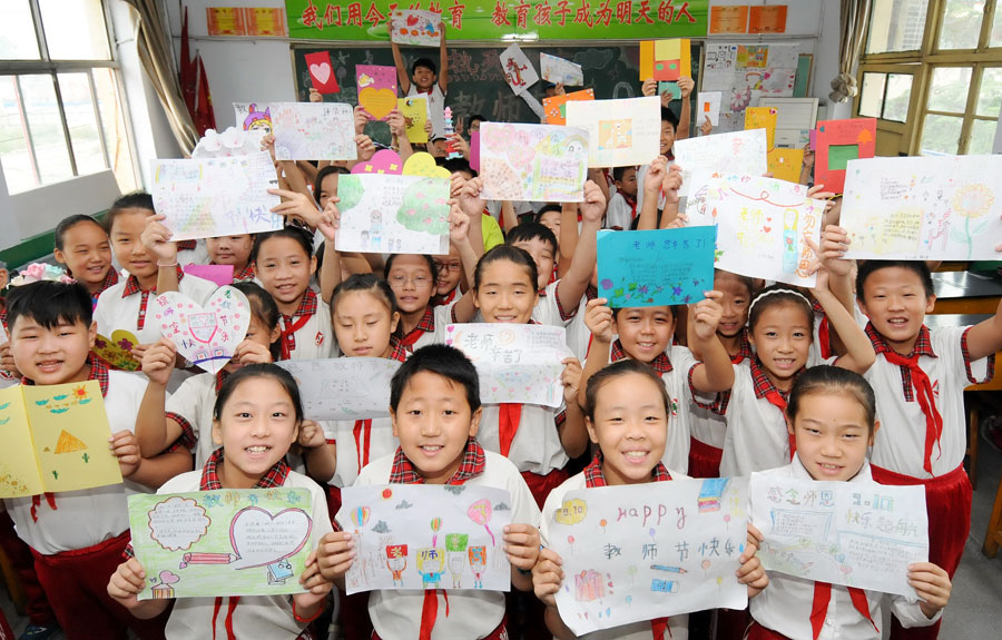 Pupils display self-made cards for teachers before Chinese Teacher's Day at Dongguan Yifu Elementary School in Shijiazhuang, capital of north China's Hebei Province, Sept. 9, 2015. China's Teacher's Day falls on Sept. 10 every year. [Xinhua]