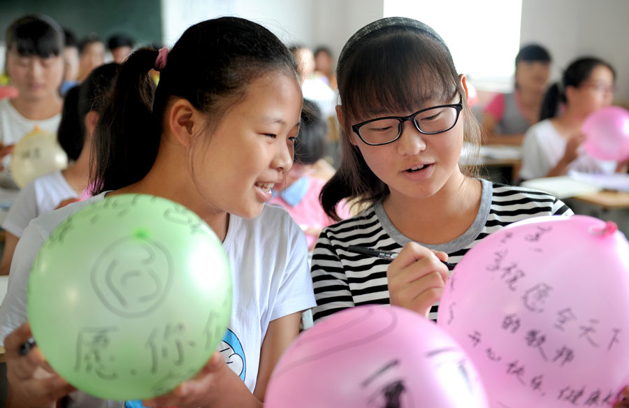 Students write wishes and blessings on balloons for teachers at the No. 1 Middle School of Shucheng City, east China's Anhui Province, Sept. 9, 2015. China's Teacher's Day falls on Sept. 10 every year. [Xinhua]