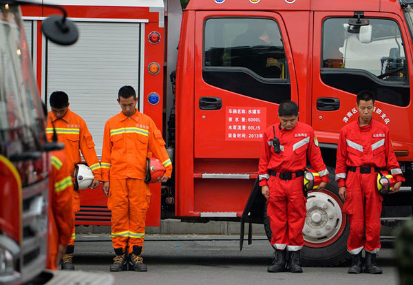 Firefighters hold three-minute silence at a ceremony to mark the seventh day since the blasts rocked a warehouse storing hazardous chemicals in Tianjin Binhai New Area, Aug 18. [Photo/Xinhua] 