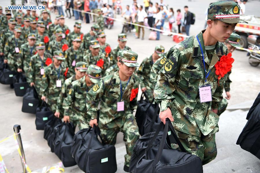 Fresh recruits of armed police force walk into a train station after a farewell ceremony in Bozhou, east China's Anhui Province, Sept. 10, 2015. The new recruits of the People's Liberation Army and paramilitary police force joined their units to fulfill their duty around the country recently. [Xinhua]