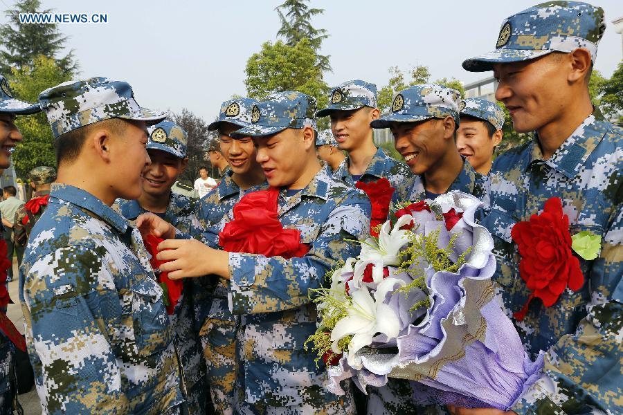 New recruits cheer for each other at the People's Armed Forces Department of Ganyu District in Lianyungang City, east China's Jiangsu Province, Sept. 10, 2015. The new recruits of the People's Liberation Army and paramilitary police force joined their units to fulfill their duty around the country recently. [Xinhua]