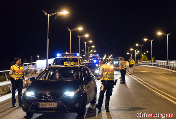 German policemen check a taxi on September 13, 2015, in the southern German city of Freilassing at the border between Germany and Austria.[Photo/China.org.cn]