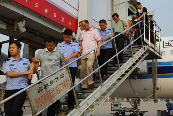 Two economic fugitives (second and fourth) are repatriated on Aug 3, 2014 from Cambodia after fleeing overseas with illicit assets. [Photo/China Daily]
