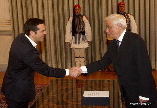 Greece's Radical Left SYRIZA party leader and winner of the general elections Alexis Tsipras (L) shakes hands with Greek President Prokopis Pavlopoulos (R), as he is sworn in as Prime Minister during a ceremony held at the Presidential Mansion in Athens, Greece, Sept. 21, 2015. (Xinhua/Marios Lolos)