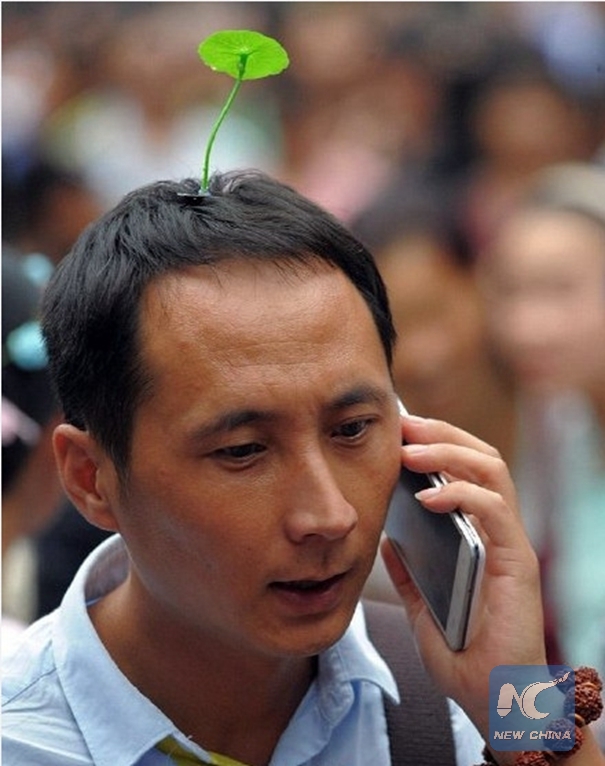 The undated photo shows a man with a hairpin on his head making phone calls. [Photo: Xinhua] 