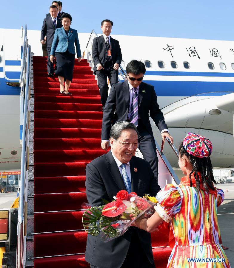 Yu Zhengsheng (L front), chairman of the National Committee of the Chinese People's Political Consultative Conference (CPPCC), who is leading a central government delegation to attend festivities marking the 60th anniversary of the establishment of Xinjiang Uygur Autonomous Region, arrives at Urumqi, capital of northwest China's Xinjiang Uygur Autonomous Region, Sept. 25, 2015. (Xinhua/Rao Aimin)