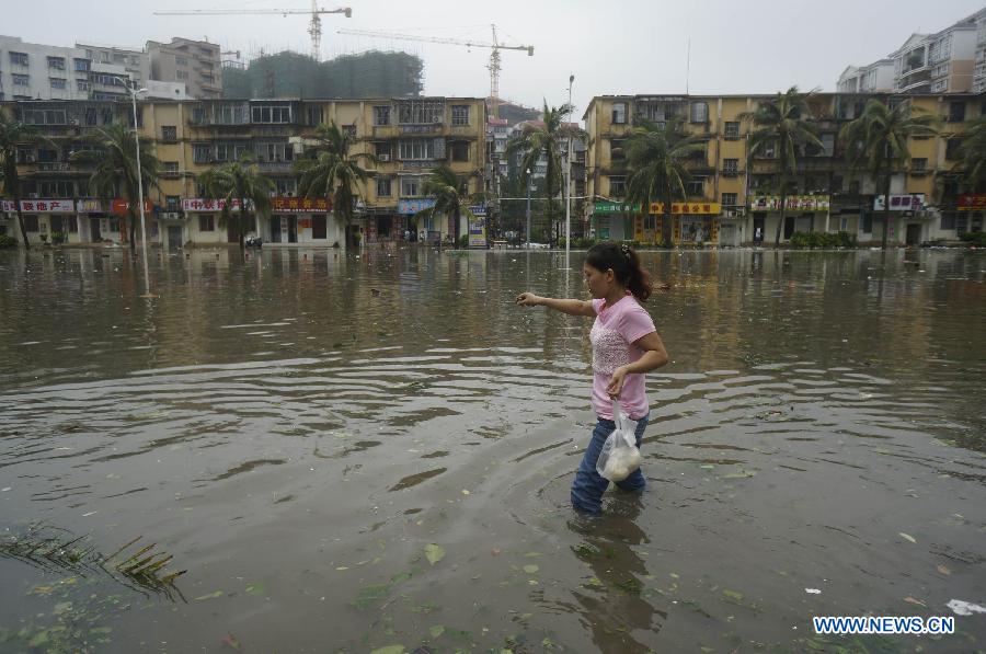 A woman walks on waterlogged road in Zhanjiang, south China's Guangdong Province, Oct. 4, 2015. Typhoon Mujigae, the 22nd typhoon this year, landed on South China's Guangdong Province on Sunday. [Photo/Xinhua]