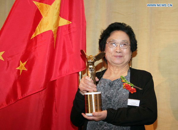 File photo taken on Sept. 23, 2011 shows Chinese pharmacologist Tu Youyou posing with her trophy after winning the Lasker Award, a prestigious U.S. medical prize, in New York, the United States. 