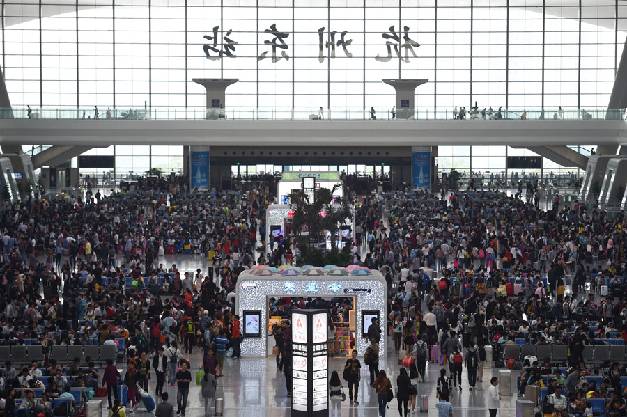 Passengers wait for their trains at the east railway station of Hangzhou, capital of east China's Zhejiang Province, Oct. 7, 2015. A travel peak is seen in Hangzhou on Wednesday, the last day of the seven-day National Day holidays. [Xinhua]