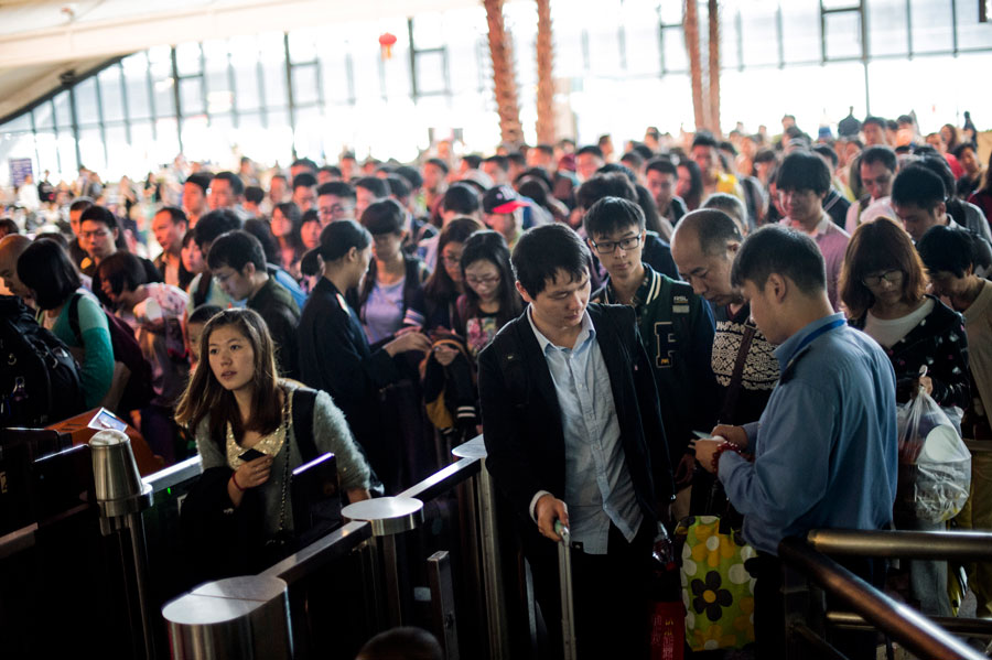 Passengers queue to board trains at the railway station of Wuhan, capital of central China's Hubei Province, Oct. 7, 2015. A travel peak is seen in Wuhan on Wednesday, the last day of the seven-day National Day holidays. [Xinhua]