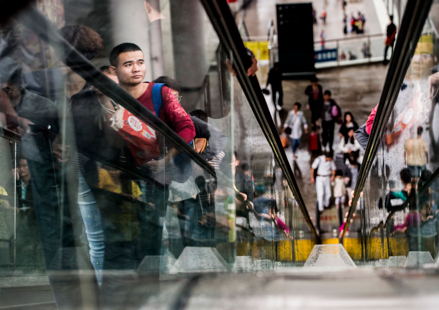 Passengers take elevators at the railway station of Wuhan, capital of central China's Hubei Province, Oct. 7, 2015. A travel peak is seen in Wuhan on Wednesday, the last day of the seven-day National Day holidays. [Xinhua]