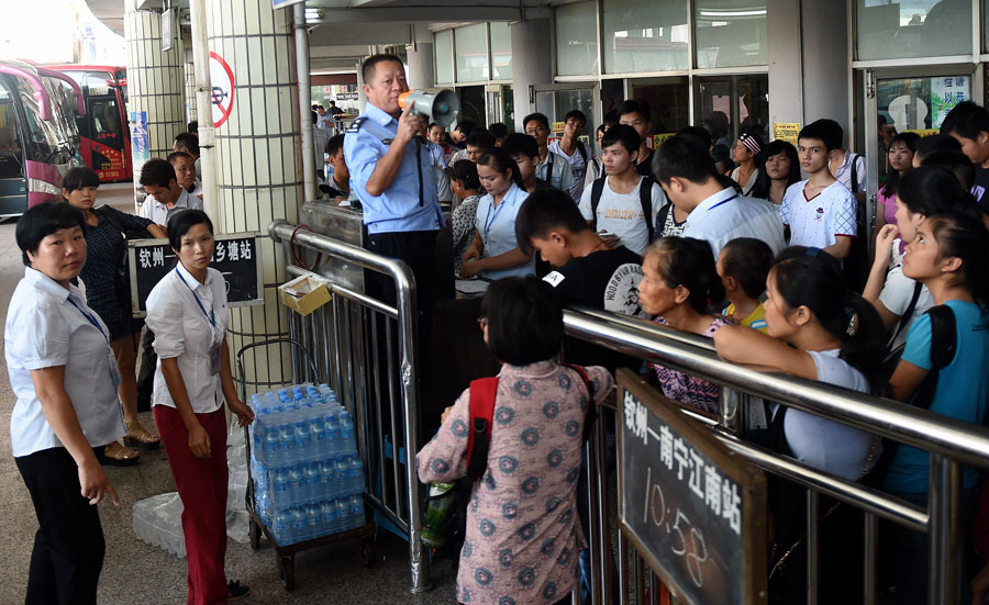 Passengers queue to board buses at the bus terminal of Qinzhou, south China's Guangxi Zhuang Autonomous Region, Oct. 7, 2015. A travel peak is seen around China on Wednesday, the last day of the seven-day National Day holidays. [Xinhua]