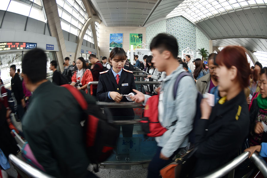 Passengers queue to board trains at the railway station of Yinchuan, capital of northwest China's Ningxia Hui Autonomous Region, Oct. 7, 2015. A travel peak is seen around China on Wednesday, the last day of the seven-day National Day holidays. [Xinhua]